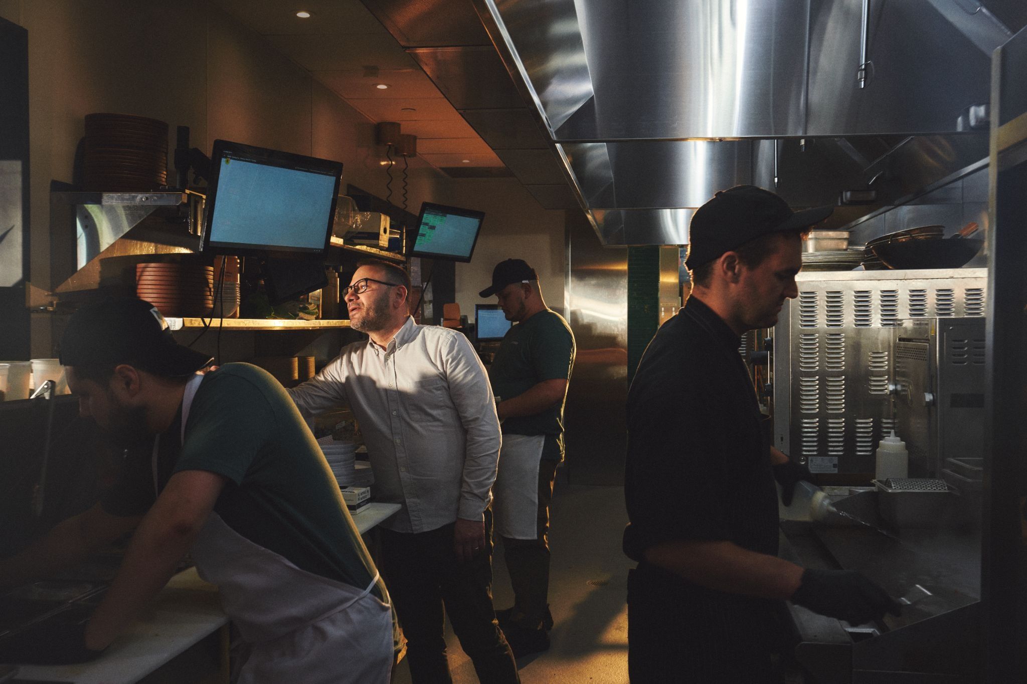 Eli peering through the service window from the kitchen of Shy Bird