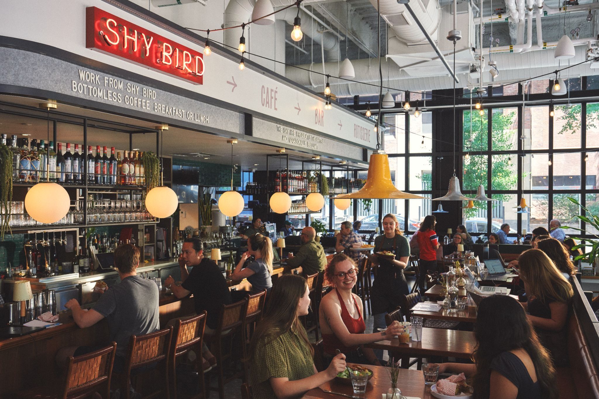 The dining room and bar of Shy Bird, full of diners for Brunch
